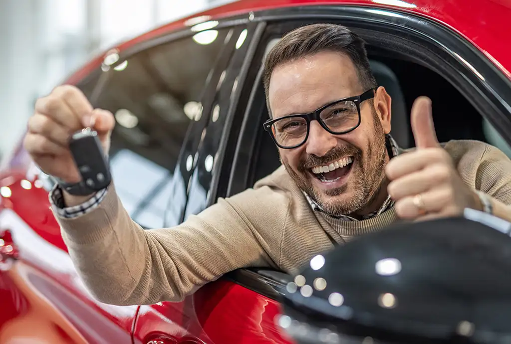 Cliente feliz recibiendo su auto financiado